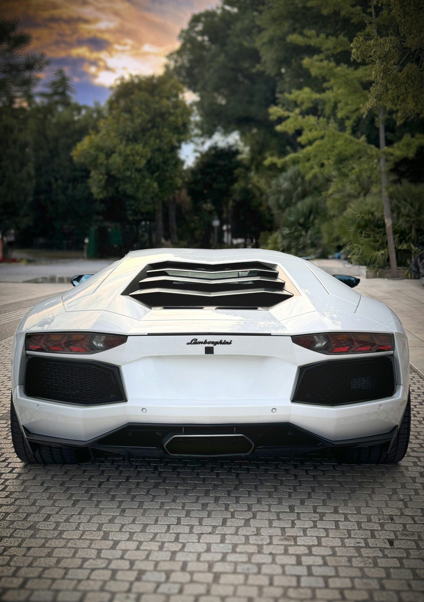 A white sports car parked on a brick road